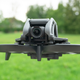 The DJI Avata drone hovering over grass.